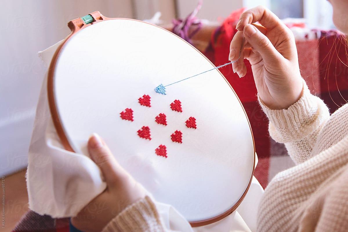 someone stitching hearts 